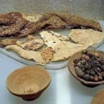 A breakfast prepared 3500 years ago consisting of bread, meat from the leg of a bull, and for dessert, a plate containing figs and dates.