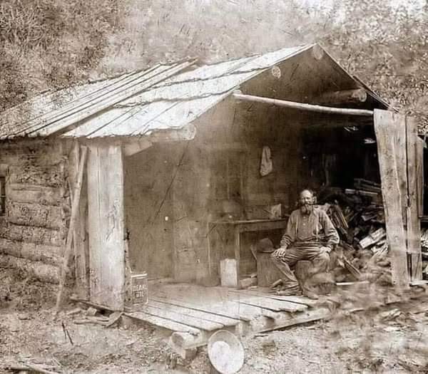 In the summer of 1889, the man sits quietly on the weathered porch of his cabin in Eagle Creek, Murray, Idaho.