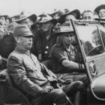 An Australian soldier driving Japanese Lieutenant General Hatazo Adachi to the Wom Airstrip, New Guinea for the formal New Guinea surrender ceremony, 13 Sep 1945