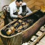 Carter and one of the foremen work on the innermost coffin of the Egyptian pharaoh (colorized photo).